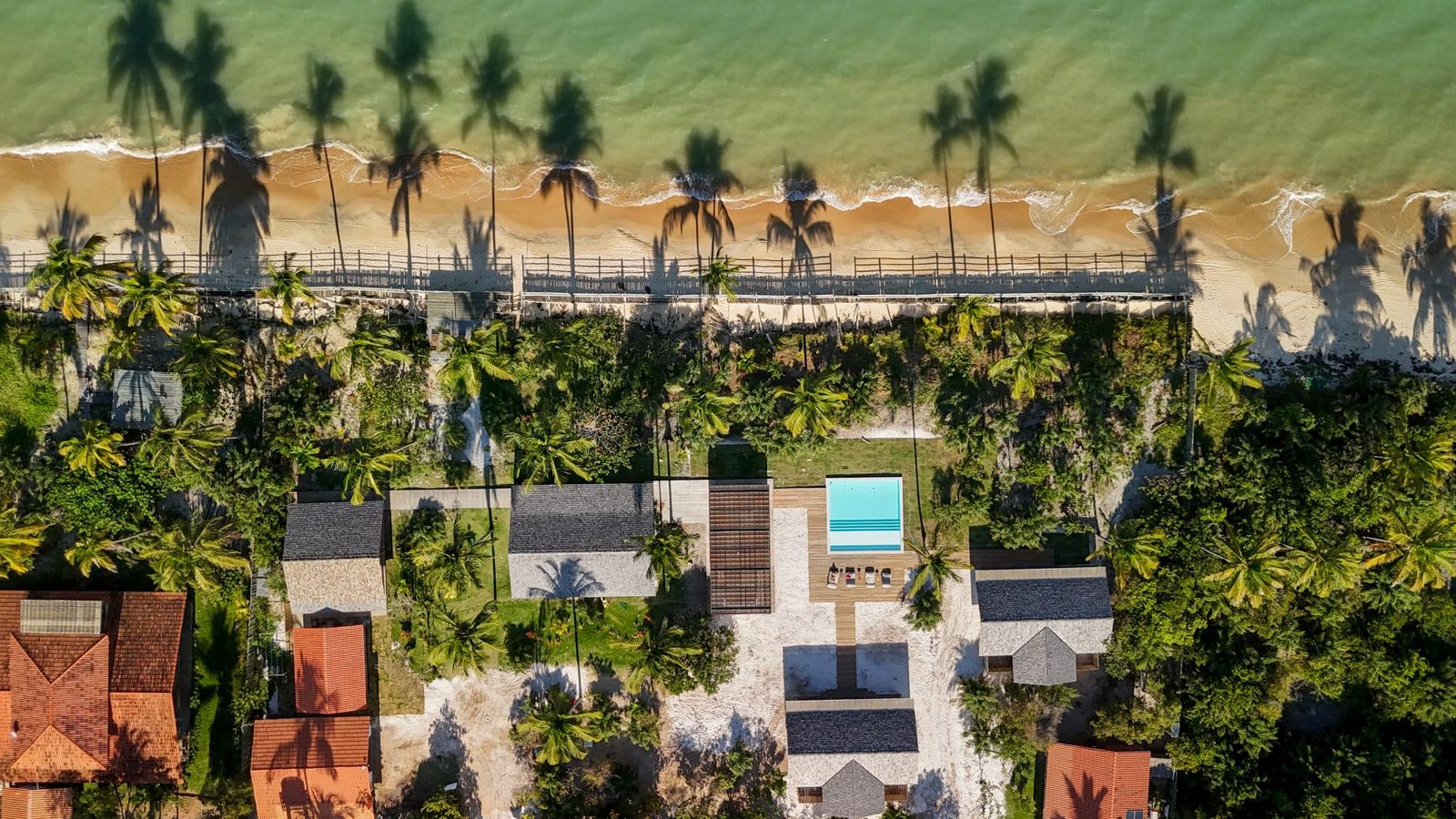 Vista aérea da casa, da piscina e da praia